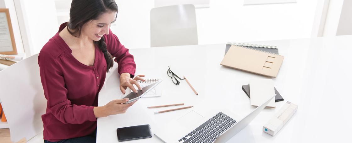 Woman using work related devices at workstation 