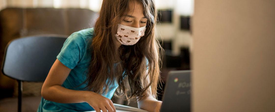 A child with a medical mask and notebook.