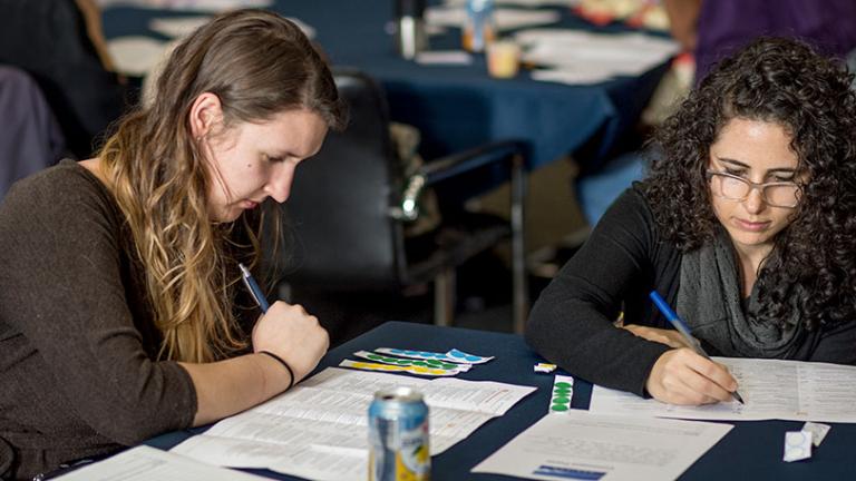 Two individuals filling out paperwork