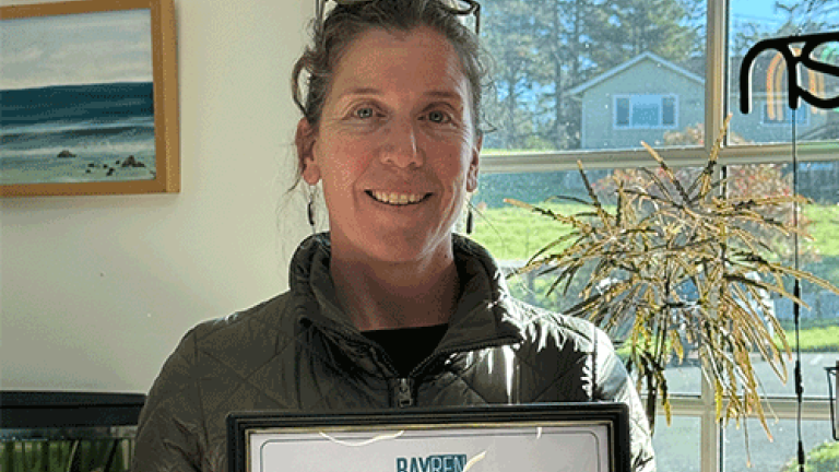 A smiling woman holding a BayREN certificate of completion.