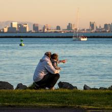 An adult and child looking onto a shoreline.